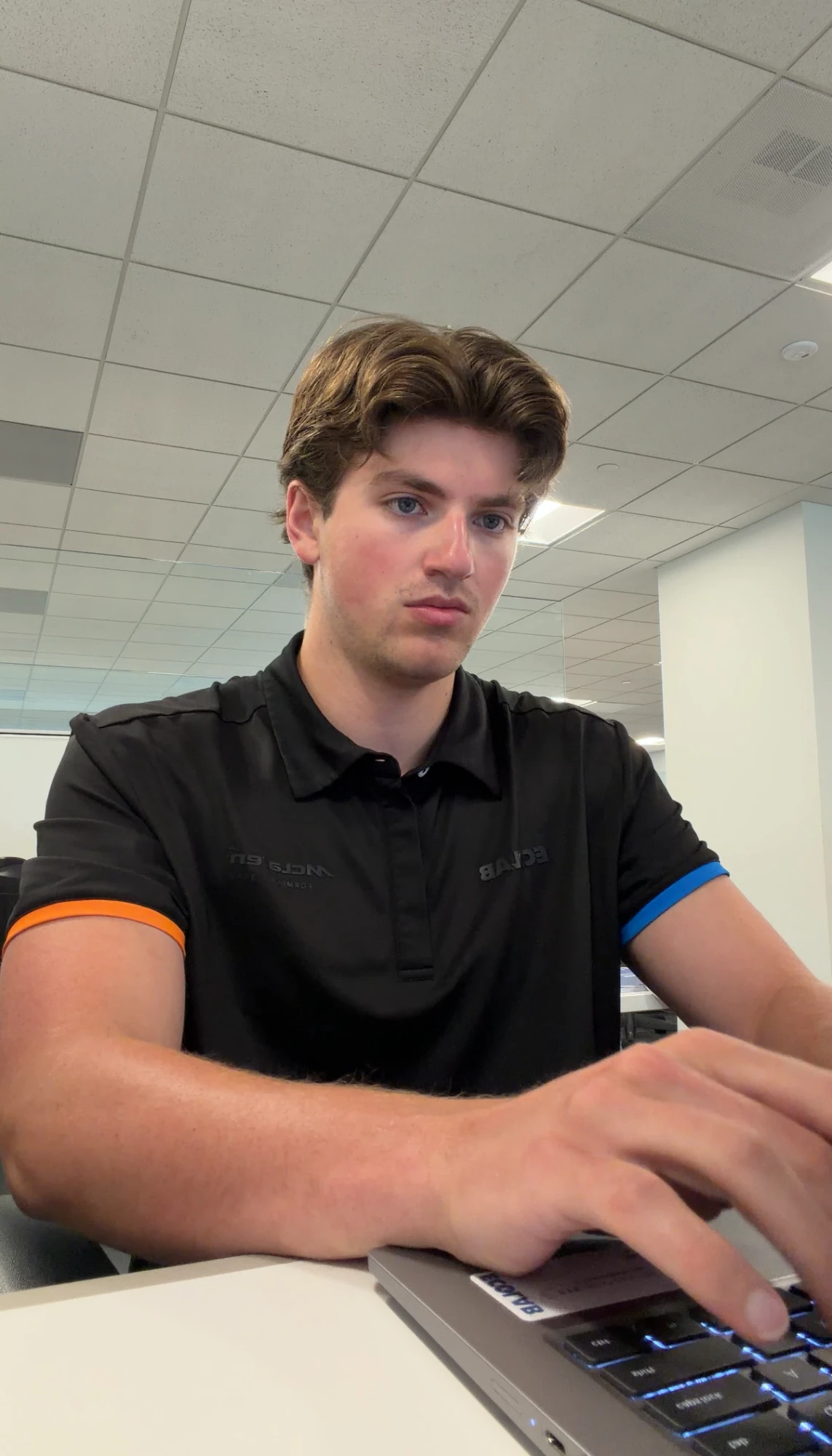 At a desk in the office, working on a laptop