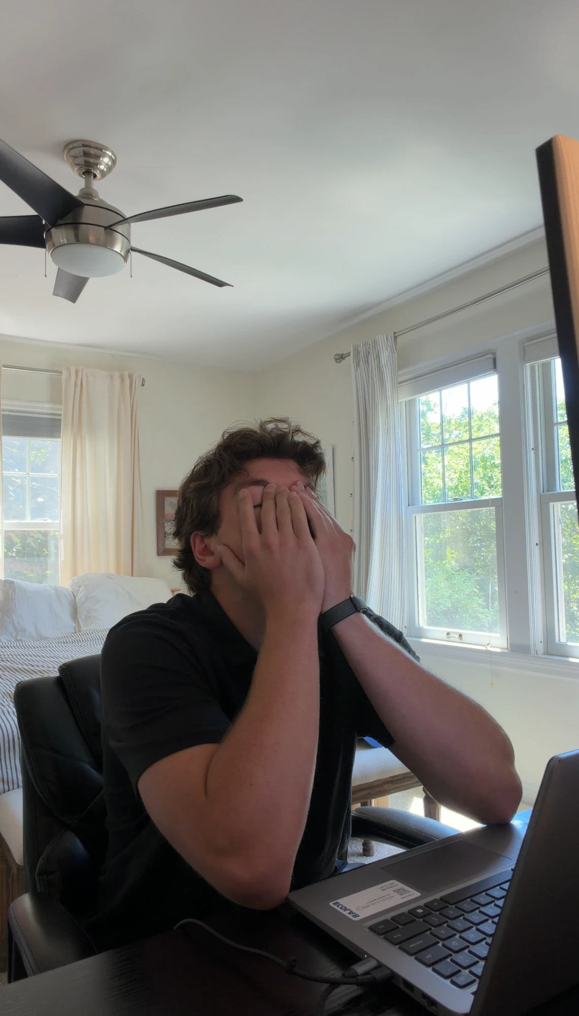 Head in hands at a home desk